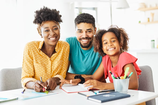 Student working on schoolwork with her parents